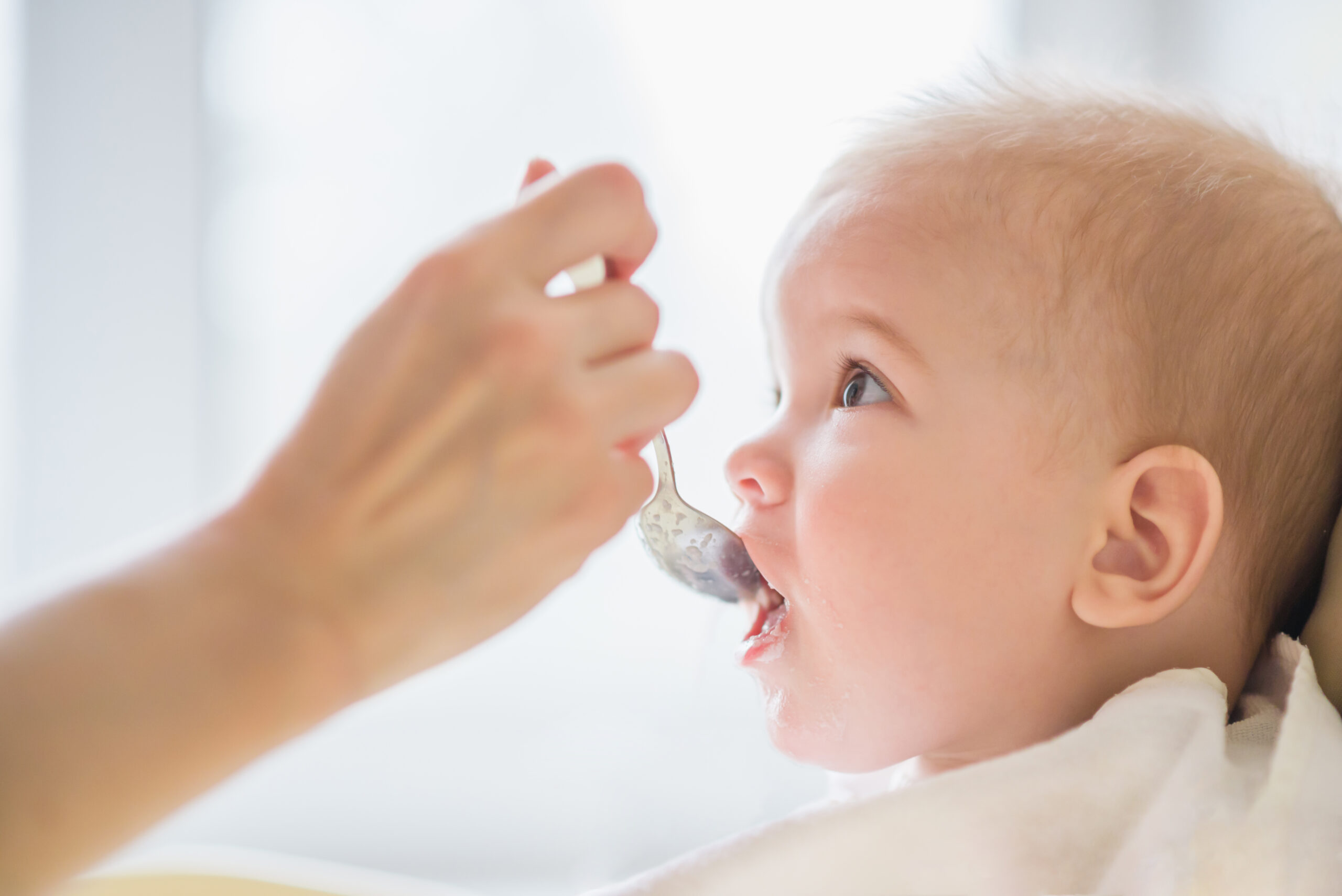 Small,Child,Sits,On,A,Chair,And,Eating,With,Spoon
